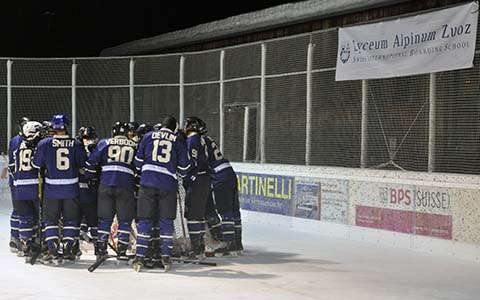 The Oxford University ice hockey team huddled together on the ice