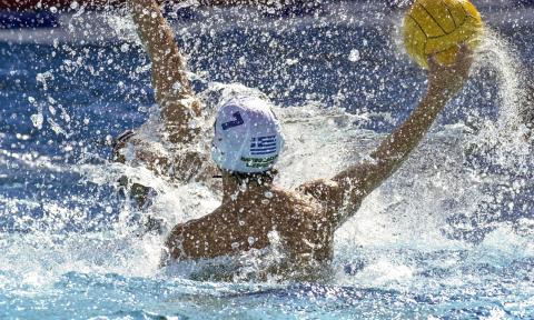 A game of water polo in progress, with a player throwing the ball passed an opponent