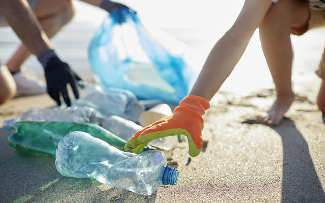 Plastic waste being retrieved by volunteers from a beach