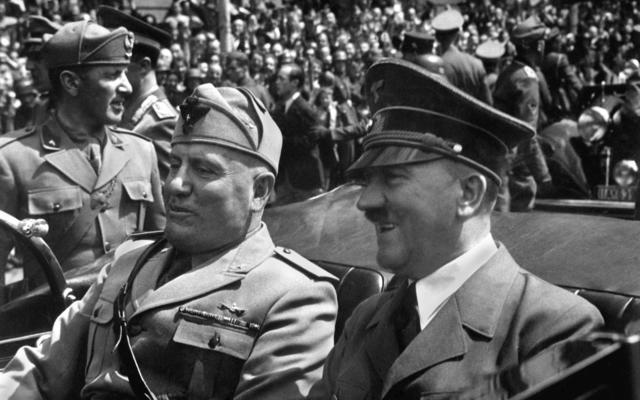 A black and white photo of Mussolini sitting next to Hitler