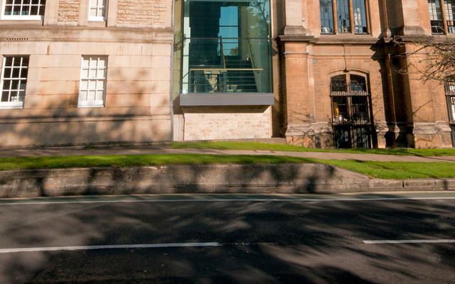 The exterior of the Radcliffe Science Library, with a woman walking in front of it