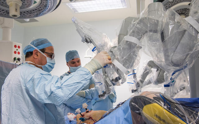Two doctors using The Da Vinci robotic platform to perform colorectal surgery