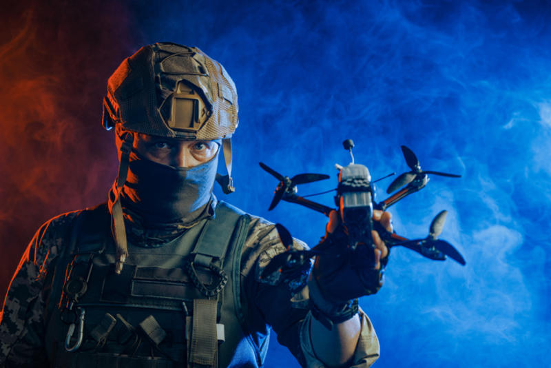 A soldier holds a drone aloft