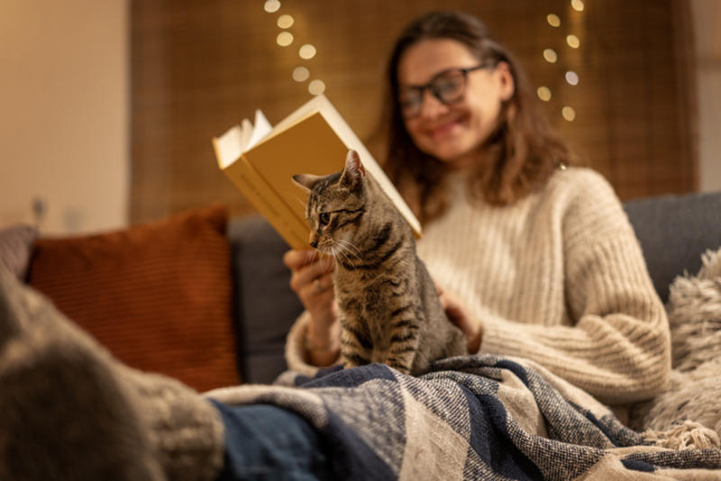 Woman reading, cat on lap