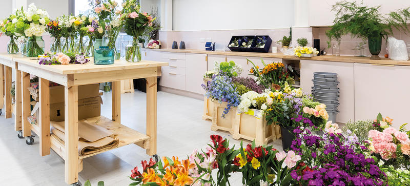 A room with table of bouquets of flowers, with equipment ready for dispatching them