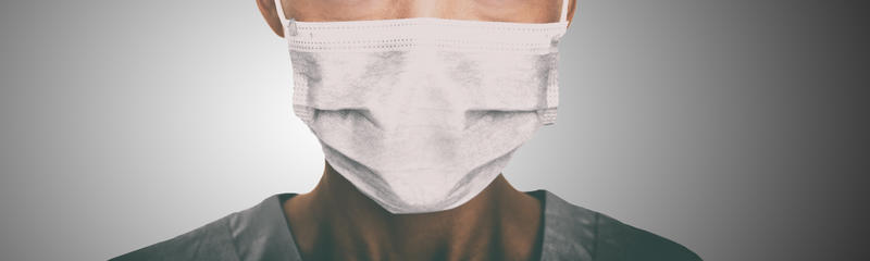 Someone in scrobs, wearing a surgical mask
