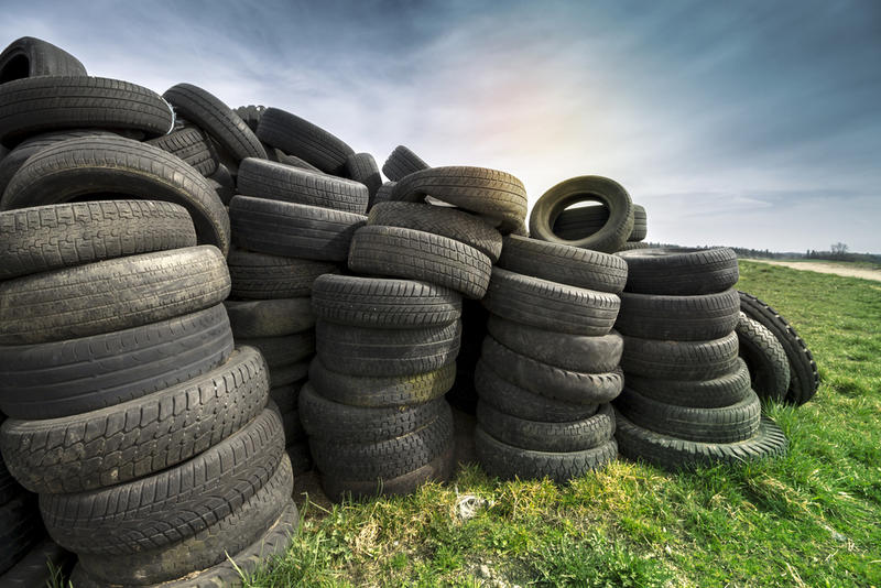A pile of car tyres in a field